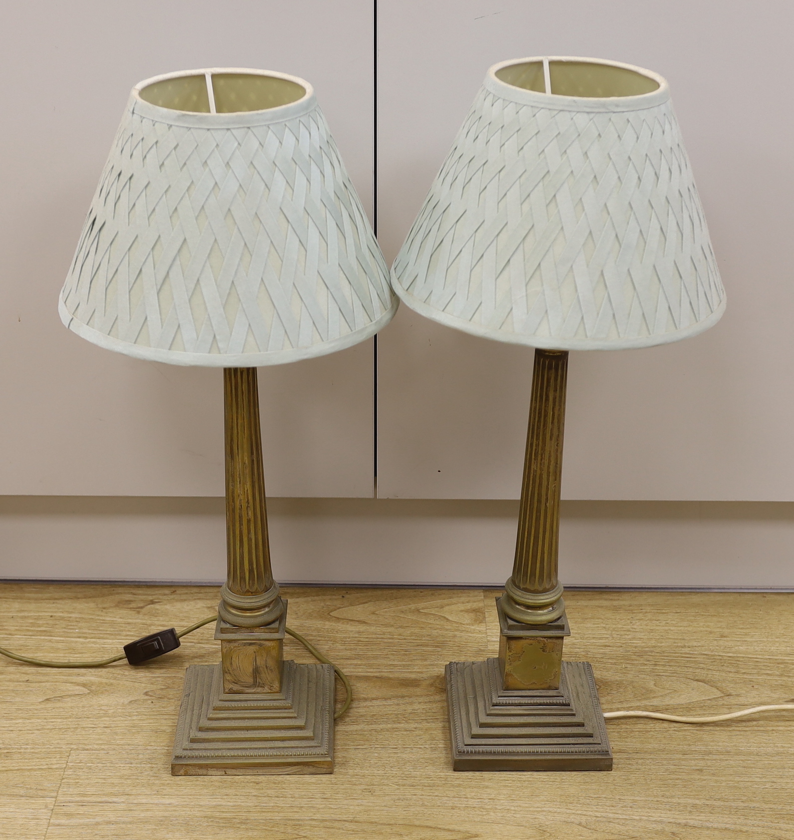 A pair of plated Corinthian column table lamps with green silk shades, 49.5cm tall